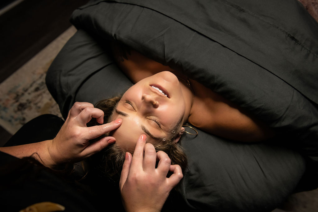 a woman receiving a cleansing facial at spa